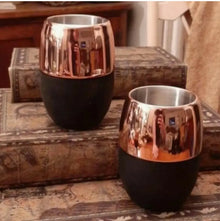 Two copper-finish insulated beverage cups on a wooden crate