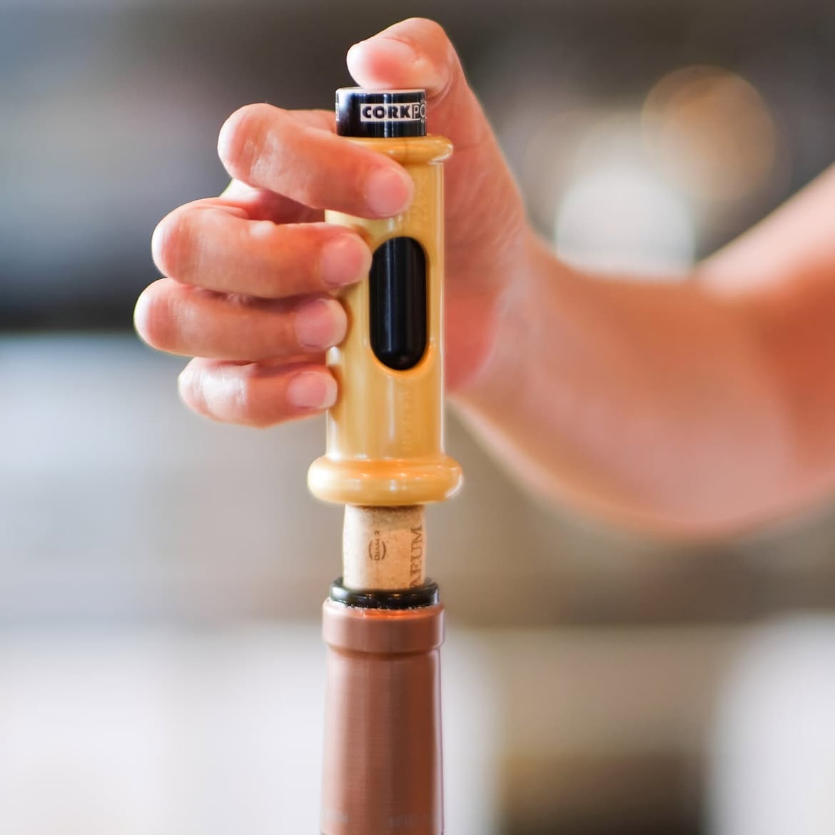 Hand pressing an Original Cork Pops opener into a bottle of wine