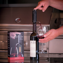 Hand pouring wine through a VinOstream dispenser on a bottle