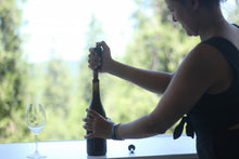 Hands opening a wine bottle with the white Giovanni opener