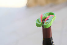Flip flop foil cutter being twisted over the top of a wine bottle